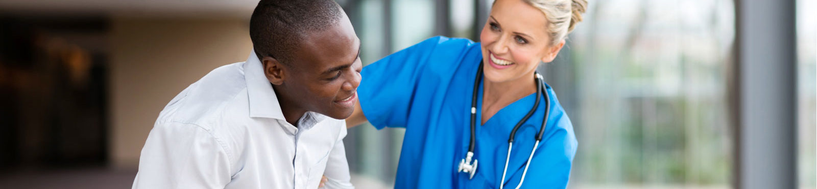 photo of a nurse assisting a young man in a wheelchair