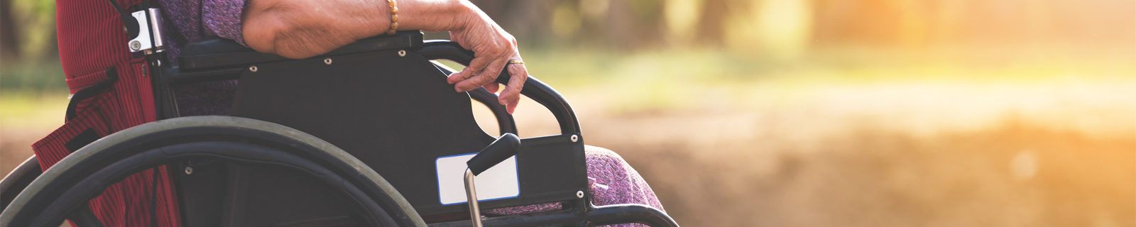 photo of a senior citizen in a wheelchair receiving Medicare assistance