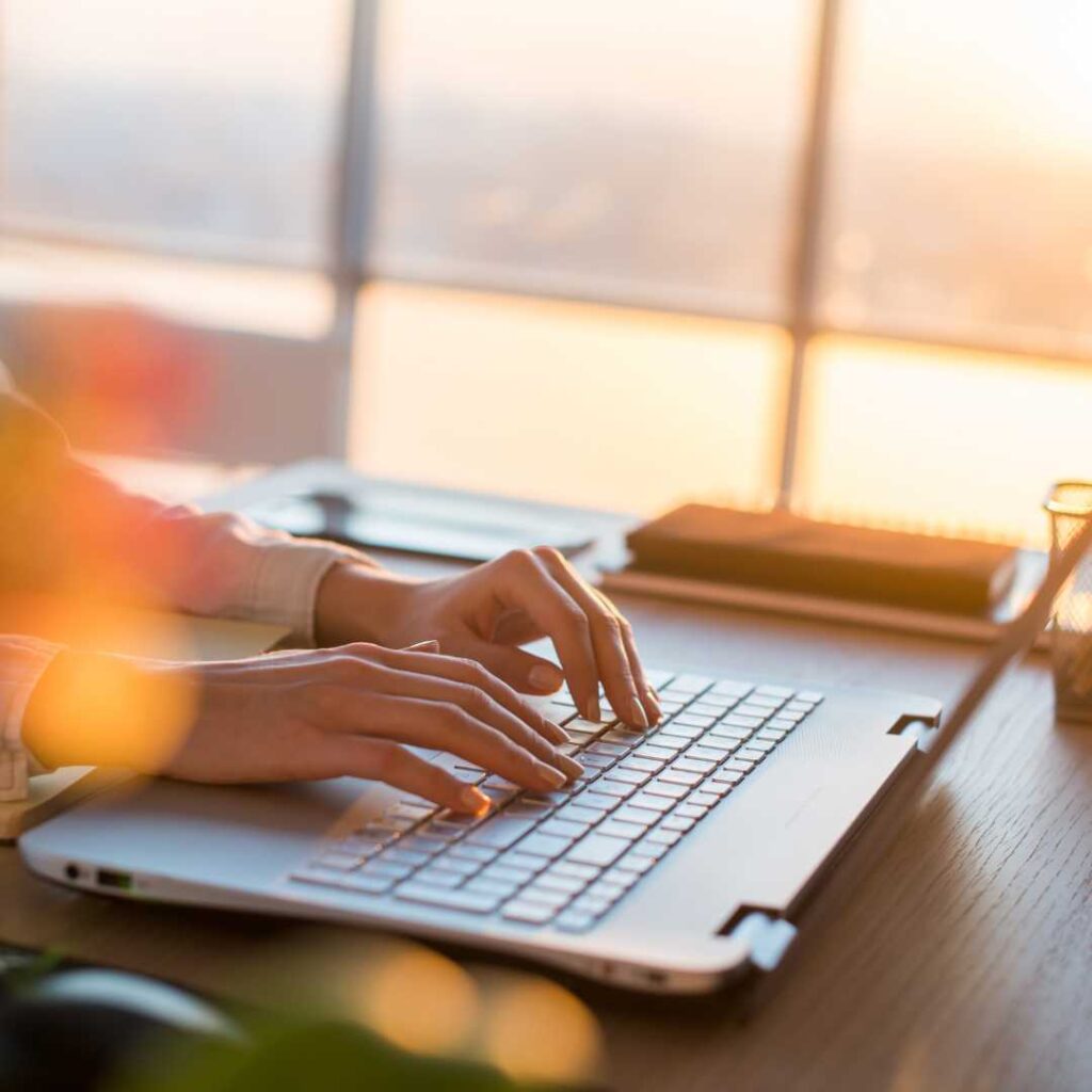 Photo of a person typing on a laptop keyboard